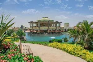 a large building with a pool in front of it at Luxury Inn 3BR Amazing view in Madinaty B2 in Madinaty