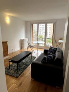 a living room with a couch and a coffee table at Appartement de standing calme - Paris - Métro 9 in Montreuil