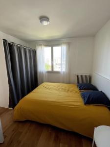 a large yellow bed in a bedroom with a window at Appartement de standing calme - Paris - Métro 9 in Montreuil
