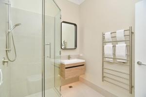 a bathroom with a shower and a sink and a mirror at Kaiapoi Luxury Accommodation 1 - Bookahome in Kaiapoi +41 photos