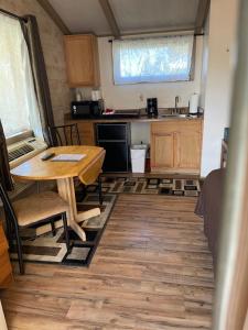 a kitchen and dining room with a table in a tiny house at Woodland Motor Lodge in Grayling