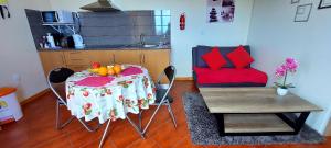 a kitchen with a table and a chair with fruit on it at Appartamento Villa in Ponta do Sol