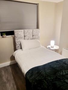 a bedroom with a large bed with a large headboard at MM Sure Stay Accommodation - NG1 in Nottingham