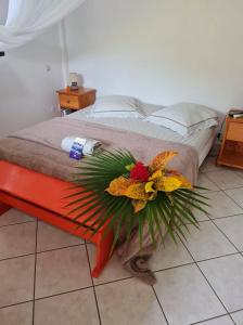 Un dormitorio con una cama con un arreglo floral. en Chez Gisèle et Philippe en Terre-de-Haut