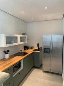 a kitchen with a stainless steel refrigerator and wooden counters at SOKZO Miramar in San Juan
