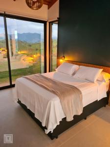 イタンヤンドゥにあるSolarium Mantiqueira - Conforto e vistas incríveisのベッドルーム1室(大きなベッド1台、大きな窓付)