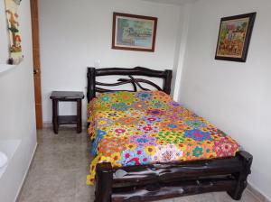 Una cama con una manta de colores en una habitación en Apartamento Pintoresco Medellín, en Medellín
