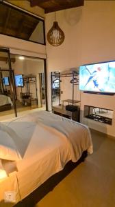 a bedroom with a bed and a large screen tv at Solarium Mantiqueira - Conforto e vistas incríveis in Itanhandu