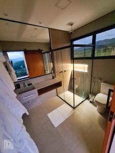 イタンヤンドゥにあるSolarium Mantiqueira - Conforto e vistas incríveisのバスルーム(ガラス張りのシャワー、トイレ付)