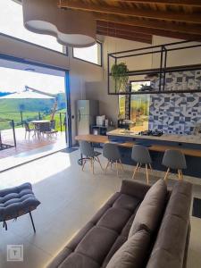 a living room with a couch and a table with chairs at Solarium Mantiqueira - Conforto e vistas incríveis in Itanhandu