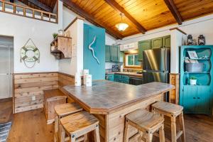 a kitchen with green cabinets and a large island with chairs at Lake Lytle Lookout in Rockaway Beach
