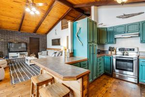 a kitchen with green cabinets and a wooden ceiling at Lake Lytle Lookout in Rockaway Beach +24 photos