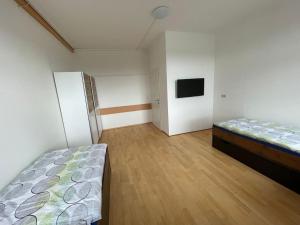 sypialnia z dwoma łóżkami i telewizorem w obiekcie Rent a Room Amstetten w mieście Amstetten +2 zdjęcia