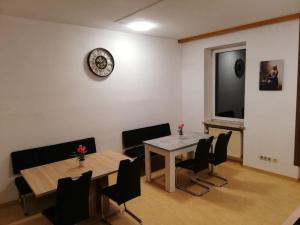 jadalnia ze stołem, krzesłami i zegarem w obiekcie Rent a Room Amstetten w mieście Amstetten
