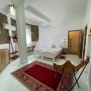 1 dormitorio con cama blanca y alfombra roja en Dune Towers en Alankuda