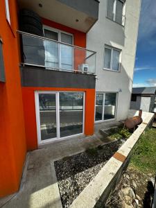 an orange and gray building with a balcony at Alvere ll Temporary Apartments Ushuaia in Ushuaia