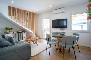 a living room with a couch and a table with chairs at Feel Nazare - Saudade 57 in Nazaré
