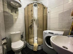 een badkamer met een toilet, een wastafel en een wasmachine bij Gerda - 1-комн. Студия в Центре in Krementsjoek