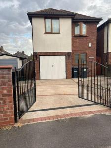 a house with a gate and a driveway at Entire -4 Bedrooms Detached House with Driveway in Nottingham