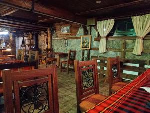 ein Esszimmer mit Holzstühlen und einer Bar in der Unterkunft КръчмЪ при Байката Alpin in Ribarica