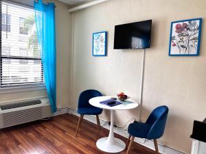 a room with a table and two chairs and a tv at Cozy Studio in the Heart of the Palm Beach Island in Palm Beach