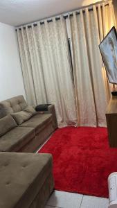 a living room with a couch and a red rug at Apartamento Mobiliado para seu conforto in Caruaru