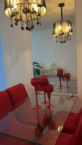 a living room with red chairs and a glass table at Apartamento Mobiliado para seu conforto in Caruaru