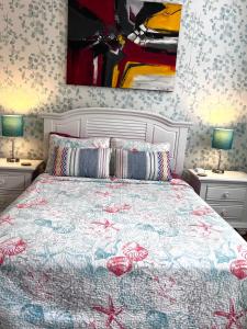 a bedroom with a bed with two lamps and a painting at Cozy Studio in the Heart of the Palm Beach Island in Palm Beach