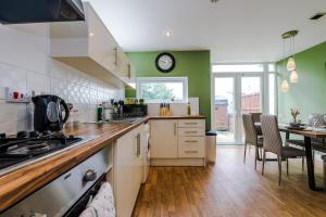a kitchen with a table and a clock on the wall at Townhouse 5mins to City Centre and Etihad - Free Secure Parking in Manchester