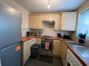 a small kitchen with a stove and a sink at Wellingborough Cosy Hub in Harrowden