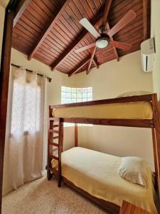 a bedroom with two bunk beds and a ceiling fan at Beach Walk Costa Rica in Playa Avellana