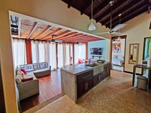 eine Küche und ein Wohnzimmer mit einem Sofa und einem Tisch in der Unterkunft Beach Walk Costa Rica in Playa Avellana