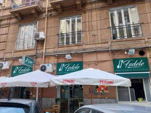 dwa białe parasole przed budynkiem w obiekcie Fra&Fra's home nel cuore del centro storico di Napoli w mieście Neapol