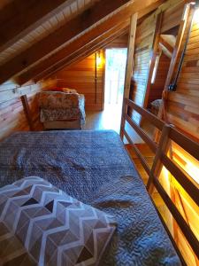 Un dormitorio con una cama y un sofá en una habitación. en Ranchinho da Serra chalé, en Bom Jardim da Serra