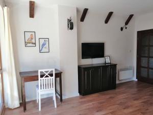 a living room with a television and a table at Студио "Птича Песен" - Studio "Birdsong", Смолянски езера in Smolyan