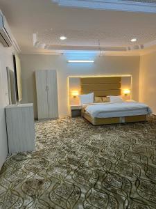 a large bedroom with a bed and a large rug at Albashier private apartment in AlUla