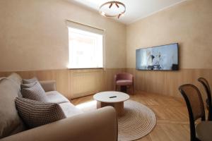 a living room with a couch and a tv at Beige Apartment in Sarajevo