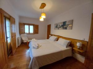 una camera d'albergo con due letti e una finestra di O Bilhó a Vinhais