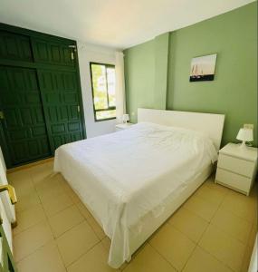 a bedroom with a white bed and green walls at Alondras park mialsoma apartment in Arona