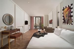 1 dormitorio con cama, escritorio y espejo en Gatto Suites&Residence, en Estambul