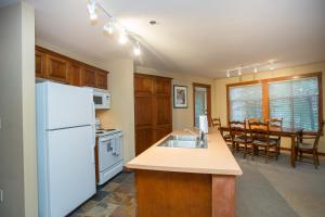 cocina con nevera blanca y mesa en 3205 - Two Bedroom Standard Powderhorn Lodge condo en Solitude