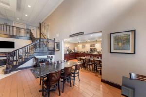 a restaurant with a table and chairs and a bar at Best Western Plus Russellville Hotel & Suites in Russellville