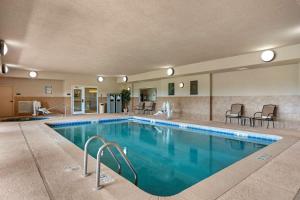 a pool in a hotel with chairs and tables at Best Western Plus Capital Inn in Jefferson City