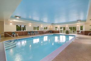 a large swimming pool with blue water in a building at Best Western Saranac Lake in Saranac Lake