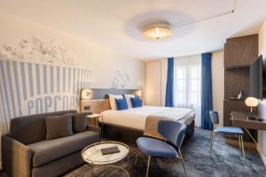 a hotel room with a bed and a couch and a chair at Best Western Plus l'Artist Hotel in Tours