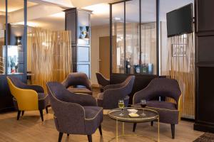 a waiting room with chairs and a table and glasses of wine at Best Western Plus l'Artist Hotel in Tours