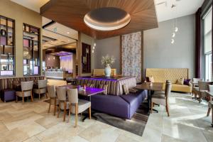 restauracja z fioletową kanapą, stołami i krzesłami w obiekcie Best Western Plus St. John's Airport Hotel and Suites w mieście St. John's