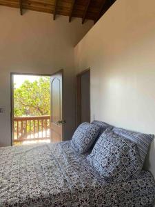 a bedroom with a bed with a view of a balcony at Lila loft- Private one floor bedroom &free parking in Roatan