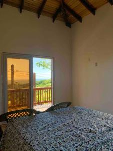 a bedroom with a bed and a large window at Lila loft- Private one floor bedroom &free parking in Roatán