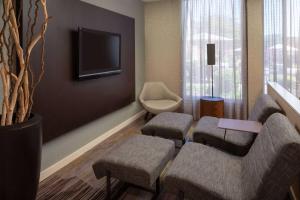 a living room with two chairs and a tv at Sonesta Select Chattanooga Hamilton Place in Chattanooga